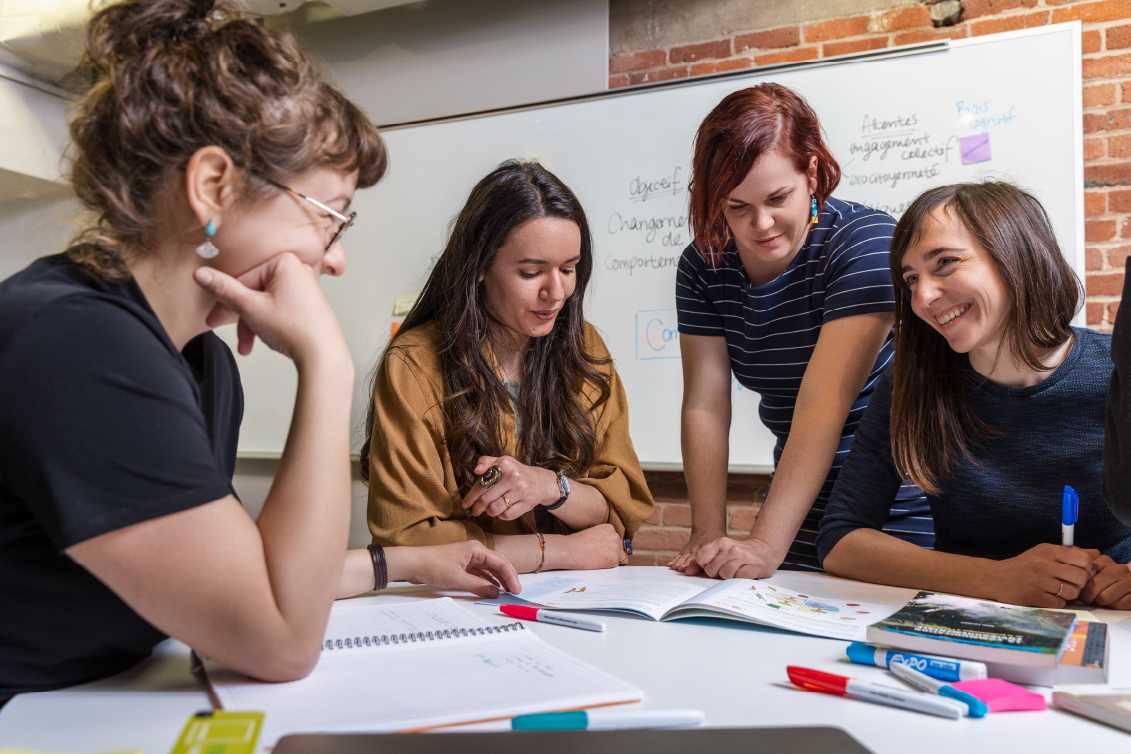 Des femmes travaillent ensemble autour de documents et crayons